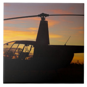 Azulejo helicóptero Robinson R44 al atardecer
