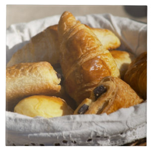 Azulejo Una cesta de mimbre para desayuno con croissants, 