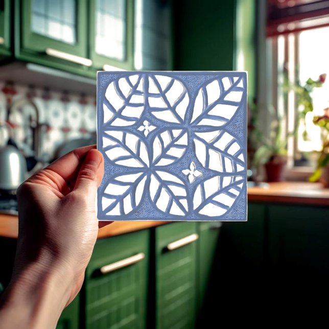 Baldosas contraportadas de cocina, cerámica azul y (Blue and white ovate leaf ceramic tile held in a hand  in front of a green kitchen.)