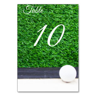 Balón de golf en número de mesa de césped verde