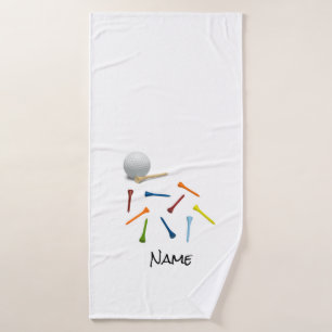 Balón de golf y té colorido sobre toalla de bañ
