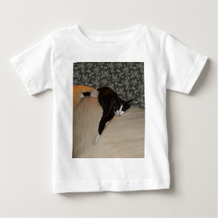 Bebé Gato durmiendo encima de la camiseta del niño del 