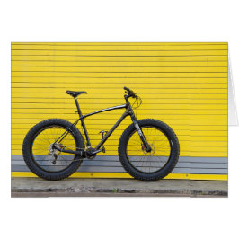 Bicicleta gorda en pared amarilla