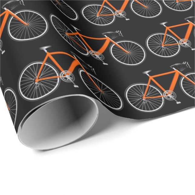 Bicicleta naranja sobre papel de envoltura negro (Esquina del rollo)