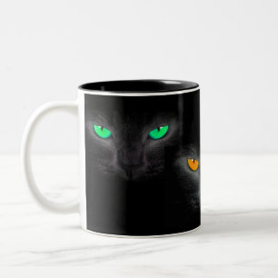 Bicolor El gato negro hace frente a la taza de café