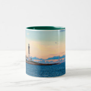 Bicolor Faro en la taza de la puesta del sol