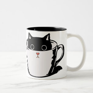 Bicolor Gatito negro con nariz roja escondido en una taza