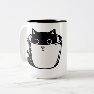 Bicolor Gatito negro con nariz roja escondido en una taza