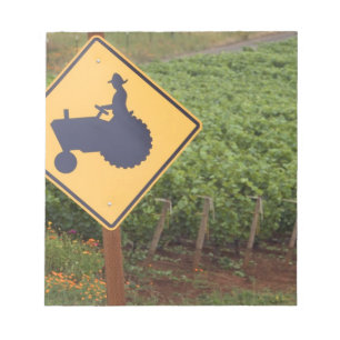 Bloc De Notas Una señal de cruce de tractor amarillo en el viñed