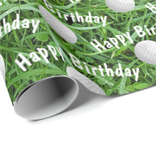 Bolas de golf de cumpleaños sobre papel de envolvi