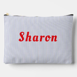 Bolsa accesoria con rayas azules y letras rojas.