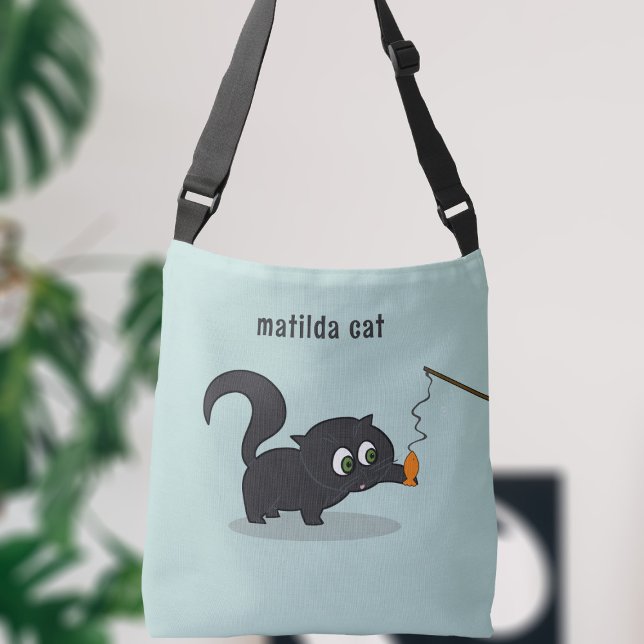 Bolsa de cruz azul de gato negro lindo (A cute little black kitty cat playing with her fish. Just add your name!)