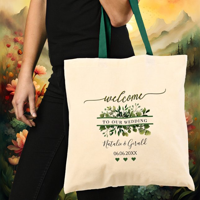 Bolsa de mano de boda con guión de bienvenida y ve (An elegant wedding tote bag featuring a stylized green welcome script text and greenery)