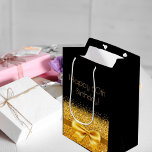 Bolsa De Regalo Mediana 60th birthday black gold bow sparkle<br><div class="desc">Elegant,  classic,  glamorous and feminine style party gift bag for a 60 year old woman.  A gold colored ribbon and bow with faux golden glitter and sparkle,  a bit of bling and luxury for a birthday.  Black background. Golden text: Happy 60th Birthday!</div>