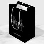 Bolsa De Regalo Mediana Groomsmen Masculino Negro Personalizado<br><div class="desc">Añada un toque personal a su boda con una bolsa de regalo personalizada para los padrinos. Este bolso de regalo presenta el nombre personalizado del groomsman con título y fecha boda en blanco y monograma en gris como fondo, en estilo clásico serif, sobre fondo negro. También perfecto para el mejor...</div>