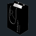 Bolsa De Regalo Mediana Simple Black Monogram Personalizado Groomsmen Medi<br><div class="desc">Esta bolsa de regalo personalizada para los padrinos negros incluye el nombre personalizado del timonel y monograma de caligrafía en color gris. Cambie el fondo y los colores de las fuentes fácilmente si lo desea.</div>