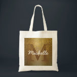 Bolsa de tote monograma personalizada, Purpurina d<br><div class="desc">El rico fondo dorado adornado con un falso purpurina de oro crea una vibración rica y casi antigua para esta bolsa de tocador. La inicial de la mujer es marrón profundo para fundirse en el resplandor dorado. El purpurina dorado se tambalea encima. El nombre de la mujer está encima en...</div>