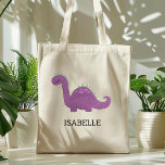 Bolsa de Tote Personalizada de Dinosaurio Púrpura<br><div class="desc">Esta bolsa de chicas contiene un ilustracion lindo de un dinosaurio morado y verde con manchas rosas y pestañas largas. Personalízalo con el nombre de su hijo en letras negras. ¡Hace una gran bolsa de libros!</div>