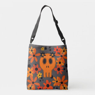 Bolso Cruzado Calavera naranja vibrante y flores en bolsa.
