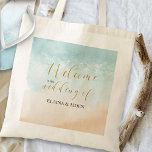 Bolso De Tela Bienvenidos a la Boda de la Playa Tropical Sandy O<br><div class="desc">bolsas de bienvenida bodas con elegantes caligrafías doradas y acuarelas en la playa. El diseño cuenta con una playa de arena tropical con bellas olas claras del océano que bordean la costa. La plantilla está lista para que agregue el nombre de la novia y el novio. Para coordinar artículos, por...</div>