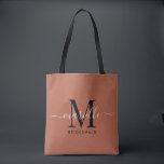 Bolso De Tela Bridesmaid Gift Gold Black Monogram Terracotta<br><div class="desc">Este bolso de tote de Bridesmaid presenta un monograma de tipografía manuscrita en blanco y negro con toques en un fondo de terracota. Presenta a tus damas de honor un tote para llevar objetos el día del boda,  y tradicionalmente se presentan en la cena de ensayo o antes.</div>