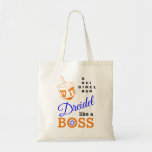 Bolso De Tela Dreidel Como Un Jefe Hanukkah<br><div class="desc">Elegante DREIDEL COMO BOSS Hanukkah Tote Bag diseñado con dreidel naranja y tipografía azul, naranja y negra. En la esquina superior derecha, puede leer los nombres de los cuatro lados dreidel en un formato de rompecabezas de palabras (HEI puede cambiarse a HEY o HAY, si es necesario). Dentro del O...</div>