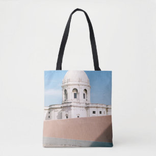 BOLSO DE TELA EDIFICIO DE CONCRETO BLANCO BAJO CIELO AZUL