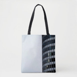 BOLSO DE TELA EDIFICIO DE CONCRETO GRIS BAJO CIELO BLANCO DURANT
