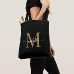 Bolso De Tela Elegante Monogramada de Giro Negro Personalizada<br><div class="desc">Moderno y Girona Sencilla Elegante Monograma Negro y Oro Nombre inicial Firma Script Personalizado Personalizado Bolsa de Tote. Este diseño presenta su primer nombre en una tipografía de tipo de letra de cola de corte con letras de bonito (o caligrafía) con monograma inicial en oro y blanco sobre negro. Gran...</div>