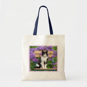 Bolso De Tela Gato de Tuxedo sentado en una silla de jardín con 