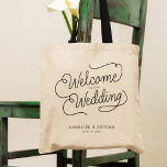 Bolso De Tela Moderno guión dorado bienvenido a nuestro favor de<br><div class="desc">Este moderno bolso de tetas con un minimalista diseño de caligrafía de escritura de moda casual leyendo BIENVENIDOS A NUESTRO BODA, así como sus nombres personalizados y fecha de nupcias, presenta líneas limpias para crear un aspecto elegante y sofisticado. El estilo sobrio, con detalles de corazón dorados y algo estampados,...</div>