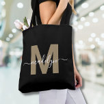 Bolso De Tela Monograma de Black Gold Trendy Script Nombre moder<br><div class="desc">Elegante Personalizado Black Gold Trendy Script Nombre Monograma Tote Bag. Añade un toque de glamour y sofisticación a tu estilo cotidiano con esta bolsa de moda. Con una inicial dorada y elegante (nota: el oro es de color plano, sin brillo ni Relieve metalizado) centrada en un fondo negro y nítido,...</div>