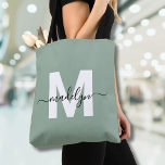 Bolso De Tela Monograma de nombre de guión moderno verde sage<br><div class="desc">Elegante Personalizado Sage Green Trendy Script Nombre Monograma Tote Bag. Añade un toque de sofisticación a tu estilo diario con esta bolsa de moda. Con una inicial blanca y elegante centrada en un fondo verde sabio suave, con un nombre de guión negro que fluye, este diseño limpio y moderno aparece...</div>