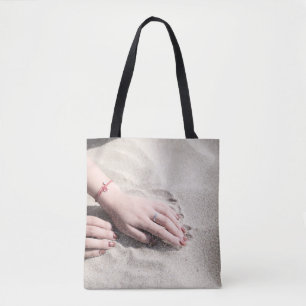 Bolso De Tela Mujer tendida sobre arena blanca