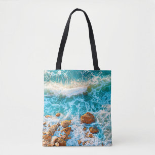 Bolso De Tela Olas en una playa rocosa al atardecer. Playa aérea