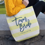 Bolso De Tela Pastel de rayas azules y amarillas<br><div class="desc">Bolsa de Tote todo-sobre-impresa con las palabras "Team Bride" en escritura de moda azul contra fondo de rayas amarillo y blanco pastel. Perfecto para bodas de dama de honor, dama de honor y chica de flores. Para ver otros colores y elementos coincidentes, vea aquí https://www.zazzle.com/collections/119250194970828530?rf=238364477188679314 Personalízalo reemplazando el texto del...</div>