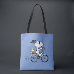 Bolso De Tela Peanuts | Snoopy & Woodstock Bicycle<br><div class="desc">Pedal into style and classic charm with this adorable cream canvas tote bag, featuring Snoopy and Woodstock on a bicycle! This fun tote showcases a delightful line-art illustration of Snoopy, wearing sunglasses, happily riding a vintage-style blue bicycle with Woodstock perched safely behind him. The dashed lines behind the back wheel...</div>