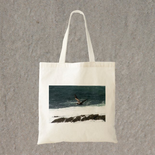Bolso De Tela Pelican volando sobre la foto del Océano Pacífico (A tote bag with a photograph of a pelican flying over the Pacific Ocean)