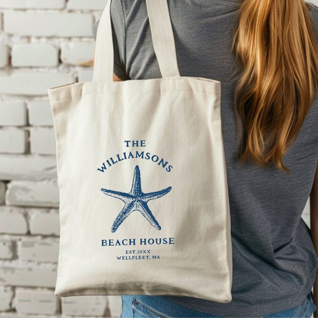Bolso De Tela Personalizado Blue Coastal Starfish Beach House (A woman with long hair carries a cream tote bag featuring a blue starfish design.)
