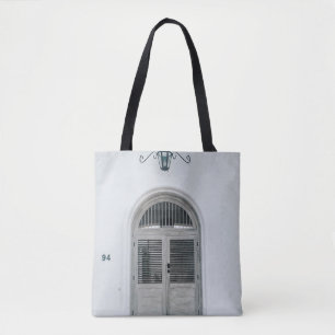 BOLSO DE TELA PUERTA DE MADERA GRIS CERRADA POR DEBAJO DE LA LUZ