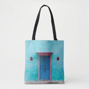 BOLSO DE TELA PUERTA DE MADERA ROJA EN PARED DE CONCRETO AZUL