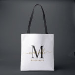 Bolso De Tela Regalo de dama de honor Oro Negro Monograma Blanco<br><div class="desc">Este bolso de tote de la dama de honor presenta un monograma de tipografía de guion dorado y negro escrito a mano con toques en un fondo blanco. Presenta a tus damas de honor un tote para llevar objetos el día del boda, y tradicionalmente se presentan en la cena de...</div>