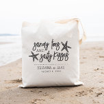 Bolso De Tela Sandy Toes & Salty Kisses Boda de Destino<br><div class="desc">Un perfecto favor o una bolsa de bienvenida para su boda de destino,  este diseño de verano de playa presenta "dedos de arena y besos salados" con letras negras y cenizas con dos estrellas de mar. Personaliza con tus nombres y la fecha de boda debajo.</div>