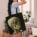 Bolso De Tela Skeleton con cigarrillo en llamas | Vincent van Go<br><div class="desc">El cráneo de un esqueleto con cigarrillo en llamas (1886) de Vincent van Gogh es un cuadro sorprendente y poco convencional que presenta un cráneo humano con un cigarrillo iluminado entre los dientes. El fondo oscuro aumenta la oscuridad de la figura esquelética, mientras que la pequeña columna de humo añade...</div>