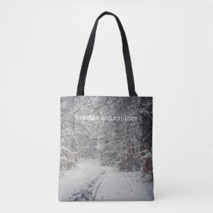 Bolso De Tela Un camino cubierto de nieve a través de un bosque 