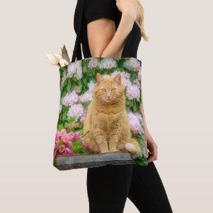 Bolso De Tela Un gato Naranja en un jardín con flores de primave