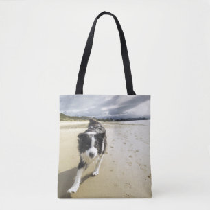 Bolso De Tela Un perro del border collie que corre en la playa
