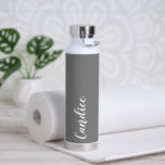 Botella De Agua Boda Gris oscuro y personalizada de dama de honor<br><div class="desc">Regale a su boda dama de honor o dama de honor con esta botella de agua insulada al vacío y a la moda que presenta su nombre en blanco y estilizado con un fondo de color gris oscuro diseñado para coincidir con su esquema de color boda. Personalice el frasco editando...</div>