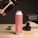 Botella De Agua Boda personalizada de Coral<br><div class="desc">Regale a su boda dama de honor o dama de honor con esta botella de agua insulada al vacío y a la moda que presenta su nombre en blanco y estilizado con un fondo de color coral diseñado para coincidir con su esquema de color boda. Personalice el frasco editando y...</div>