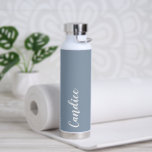 Botella De Agua Boda personalizada Dusty Blue<br><div class="desc">Regale a su boda dama de honor o dama de honor con esta botella de agua insulada al vacío y a la moda que presenta su nombre en blanco y estilizado con un polvoriento fondo de color azul diseñado para coincidir con el esquema de color boda. Personalice el frasco editando...</div>